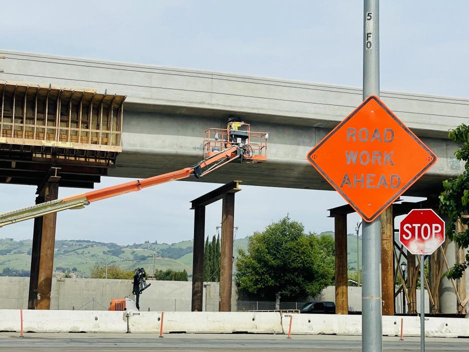 A cement mason working under a bridge