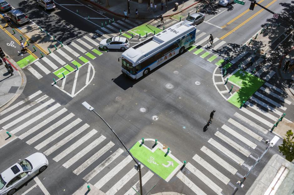 Aerial photo of a protected intersection with a bus and cars using it.