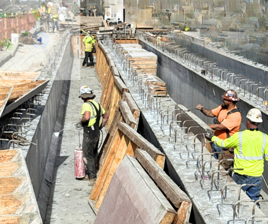 Construction workers remove the formwork from the bridge stem wall and apply curing compound. [Photo VTA/EBRC].  