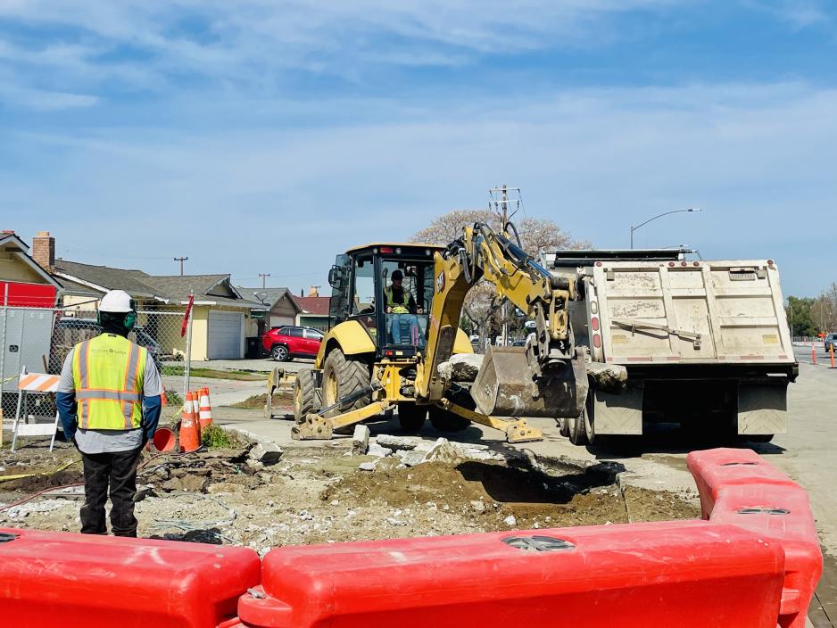 Construction workers and heavy equipment performing demolition work